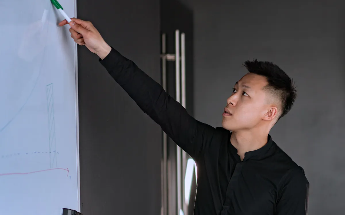 一个人在白板前带领，其他人参与一场工作坊。